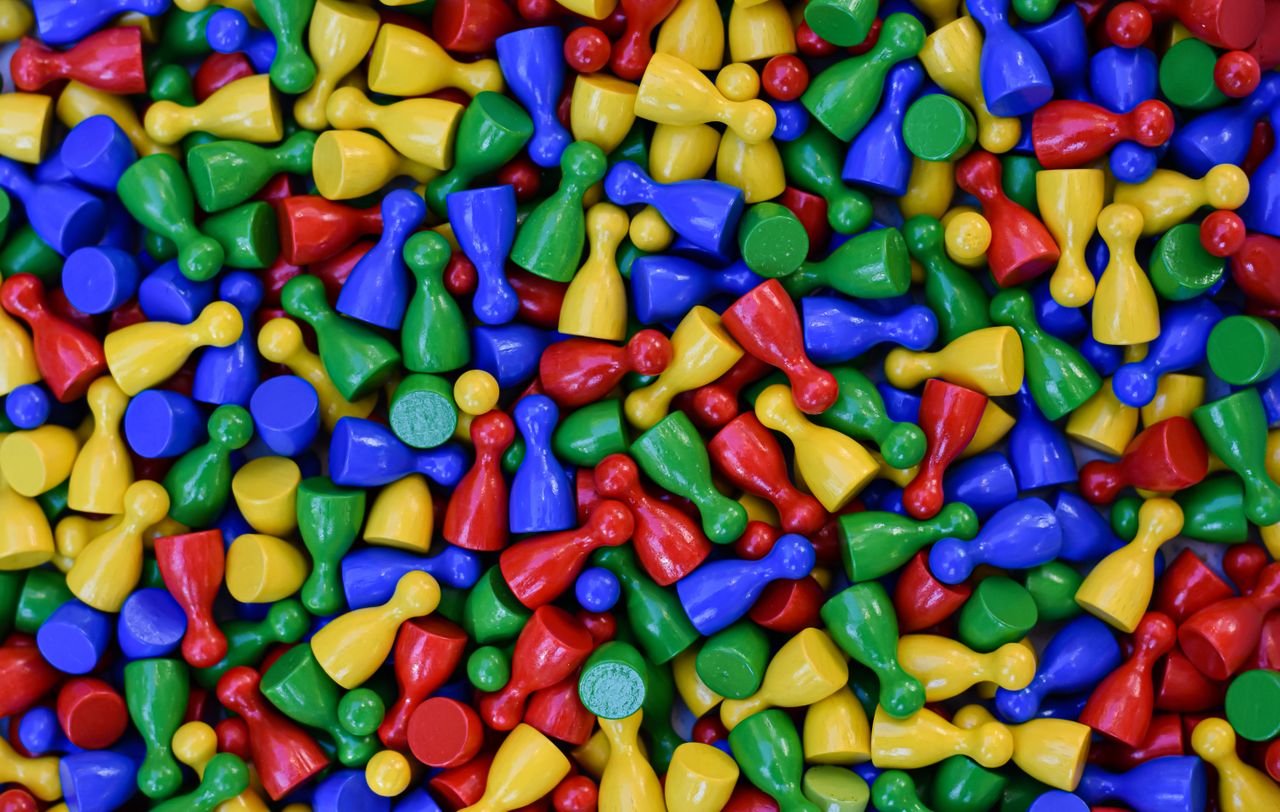 An array of colorful board game pieces scattered in a playful pattern.